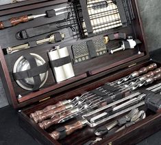 an open wooden box filled with different types of kitchen utensils