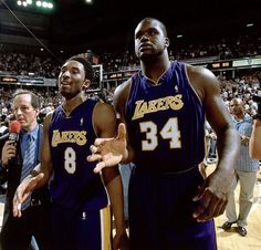 two basketball players standing next to each other in front of an audience at a game