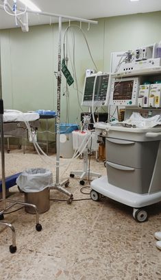 an operating room with multiple monitors and medical equipment on the floor next to each other