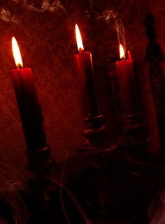 three lit candles sitting on top of a table