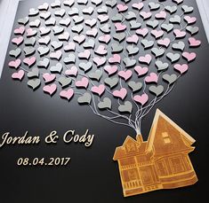 a couple's house and tree made out of hearts is displayed on a plaque