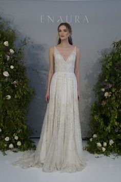 a woman in a white dress standing next to flowers