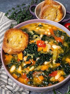 a bowl of vegetable soup with bread on the side