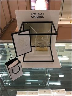 a display case with chanel perfumes and jewelry on it's glass shelves