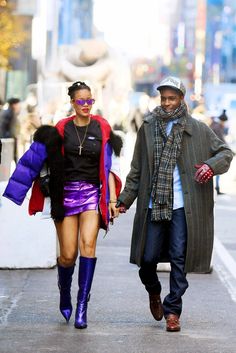 a man and woman walking down the street in high heels, jackets and sweaters