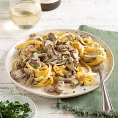 a white plate topped with pasta covered in mushrooms