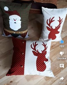 two christmas pillows sitting on top of a wooden floor