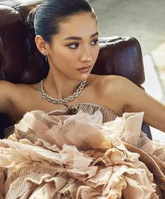 a woman sitting in a chair wearing a dress