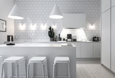 two white stools sit in front of a kitchen island