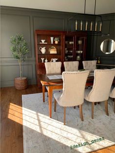 a dining room table and chairs in front of a china cabinet