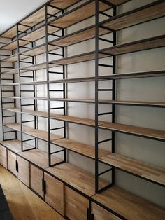 an empty room with shelves and wooden floors