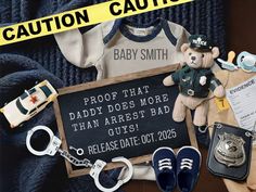 baby clothes, keys, and handcuffs are laid out in front of a police caution sign