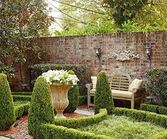 a garden with hedges and benches in the middle