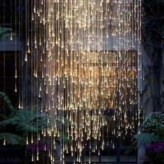 a large chandelier hanging from the ceiling in front of a building with lots of lights