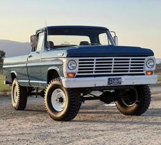 an old pickup truck parked in the dirt