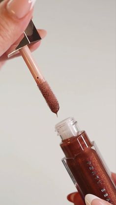 A shot of a Fenty Gloss Bomb Universal Lip Luminizer in Hot Chocolit being opened. Fenty Beauty Hot Chocolate Gloss, Ugc Lip Gloss, Beauty Content Creator Aesthetic, Fenty Hot Chocolate Lip Gloss, Fenty Beauty Aesthetic, Cosmetics Photoshoot, Lip Gloss Aesthetic, Gloss Aesthetic, Makeup Gloss