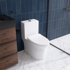 a white toilet sitting in a bathroom next to a wooden cabinet and blue tiled walls