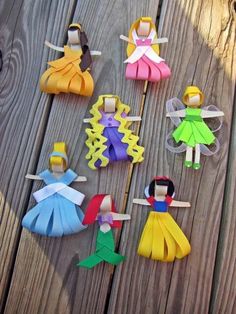 paper dolls are arranged on a wooden table