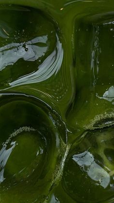 green liquid flowing down the side of a wall in an abstract pattern with white and black dots