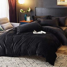 a bed with black sheets and pillows in a room