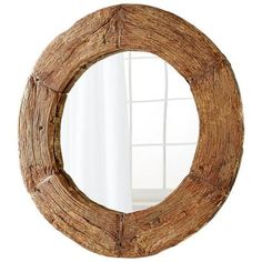 a round wooden mirror hanging on the wall