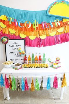 a table topped with drinks and tassels next to a sign that says happy birthday