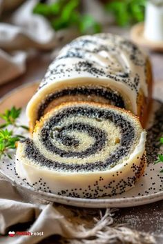 a plate topped with a roll covered in black and white frosting