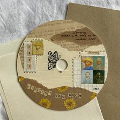 a cd that is sitting on top of an envelope with some pictures and words on it