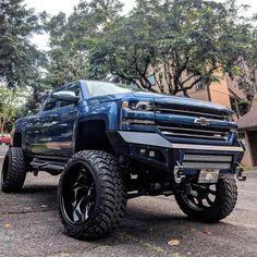 a large blue truck parked on top of a parking lot