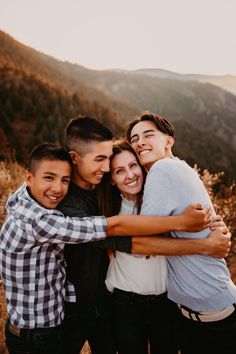 a group of friends hugging each other in the mountains