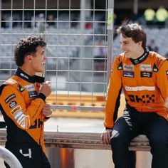 two men sitting on a bench talking to each other