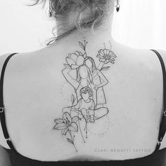 the back of a woman's shoulder with flowers and a girl holding a flower