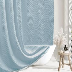 a bath tub sitting under a blue shower curtain