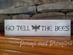 a wooden sign that says go tell the bees