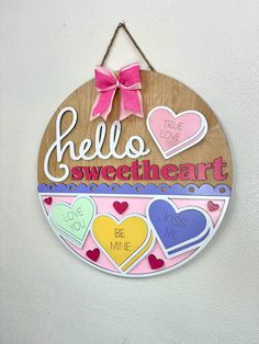 a wooden sign that says hello sweet heart with hearts hanging from the front and side