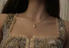 a woman wearing a necklace with a heart on it