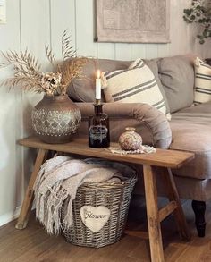 a living room with a couch, table and baskets on the floor in front of it