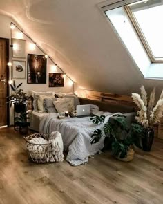 an attic bedroom with wooden floors and white walls, decorated in neutrals and whites