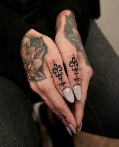 a woman's hands with tattoos on them