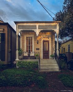 a small house with a front door and steps leading up to the entryway,