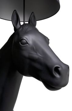 a black horse head mounted to the side of a lamp