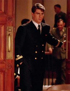 the young man is dressed in his uniform and walking into the room with other people