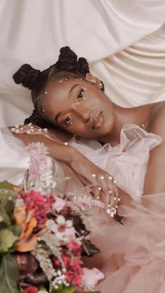 a woman laying on top of a bed next to flowers