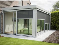 an outdoor room with sliding glass doors on the outside and green grass in the front yard