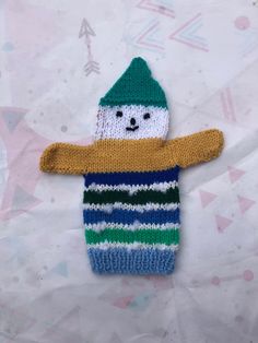 a knitted snowman ornament on a sheet