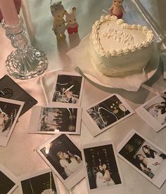 a table topped with lots of pictures and a heart shaped cake on top of it