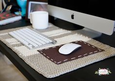 an apple computer sitting on top of a desk next to a keyboard and mouse pad