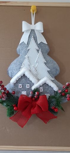 a felt christmas tree decoration hanging on a wall