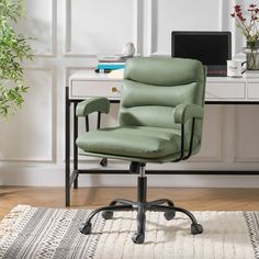 a green office chair sitting in front of a desk