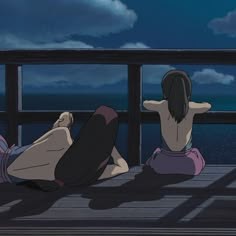 two people sitting on a deck looking out at the ocean with their backs to each other